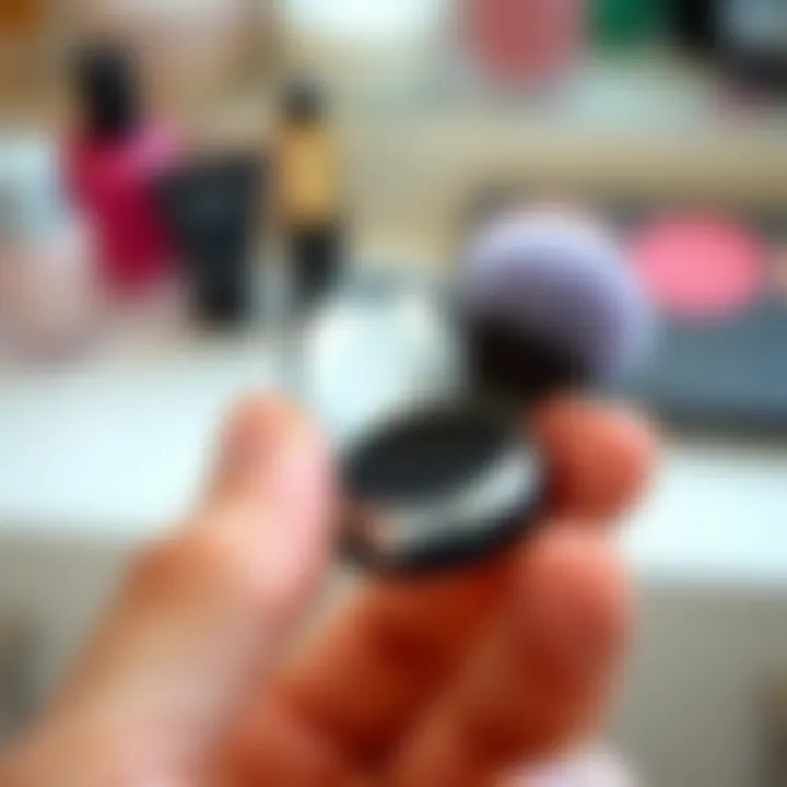 Close-up of a hand holding a compact makeup brush